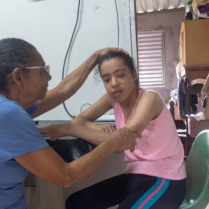 Vó Cema acariciando a cabeça da neta